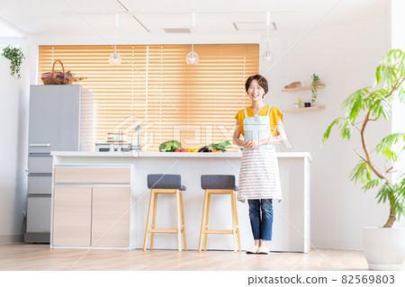 站立在廚房裡的微笑的中部婦女 82569803