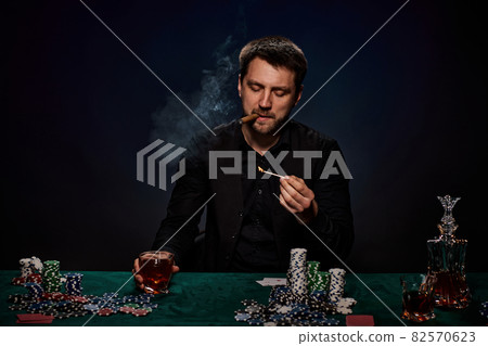 Bearded casino player man playing poker on green table 82570623
