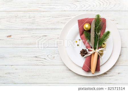 Christmas table place setting with christmas decor and plates, kine, fork and spoon. Christmas holiday background. Top view with copy space 82571514