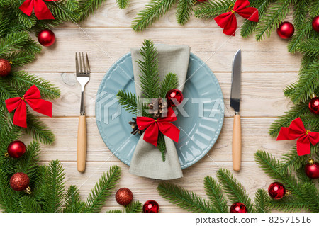 Christmas table place setting with christmas decor and plates, kine, fork and spoon. Christmas holiday background. Top view 82571516