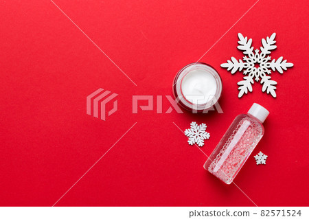 Makeup products and Christmas decorations on color background. Top view New year Beauty concept with copy space 82571524