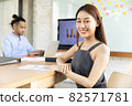 Portrait of a happy casual asian businesswoman  sitting at her workplace in office.She doing some paperwork at the office.Businesspeople smiling coworking commenting and showing growth graphic and 82571781