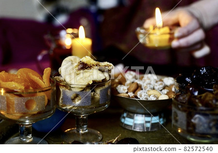 Black Turkish tea in lale with oriental sweets and dried fruits by candlelight 82572540