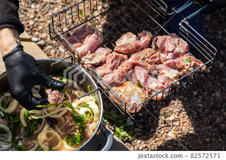 Cook lays cubes of marinated turkey meat 82572571