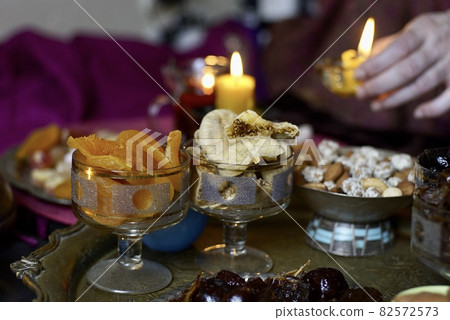 Black Turkish tea in lale with oriental sweets and dried fruits by candlelight 82572573