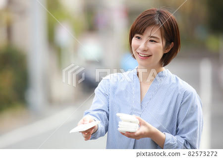 Woman giving out tissue Woman giving out tissue 82573272