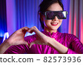 Neon  asian woman dancing. Fashion model woman in neon light, portrait of beautiful model with fluorescent make-up, Art and future design of female disco dancer posing in UV, colorful make up. 82573936