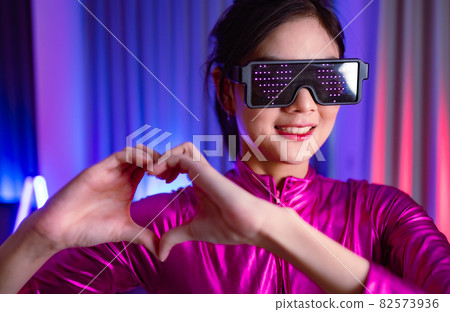 Neon asian woman dancing. Fashion model woman in neon light, portrait of beautiful model with fluorescent make-up, Art and future design of female disco dancer posing in UV, colorful make up. Neon asian woman dancing. Fashion model woman in neon light, portrait of beautiful model with fluorescent make-up, Art and future design of female disco dancer posing in UV, colorful make up. 82573936