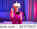 Neon  asian woman dancing. Fashion model woman in neon light, portrait of beautiful model with fluorescent make-up, Art and future design of female disco dancer posing in UV, colorful make up. 82573937