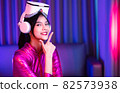 Neon  asian woman dancing. Fashion model woman in neon light, portrait of beautiful model with fluorescent make-up, Art and future design of female disco dancer posing in UV, colorful make up. 82573938