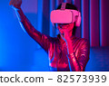 Neon  asian woman dancing. Fashion model woman in neon light, portrait of beautiful model with fluorescent make-up, Art and future design of female disco dancer posing in UV, colorful make up. 82573939