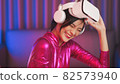 Neon  asian woman dancing. Fashion model woman in neon light, portrait of beautiful model with fluorescent make-up, Art and future design of female disco dancer posing in UV, colorful make up. 82573940