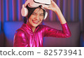 Neon  asian woman dancing. Fashion model woman in neon light, portrait of beautiful model with fluorescent make-up, Art and future design of female disco dancer posing in UV, colorful make up. 82573941