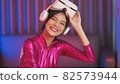 Neon  asian woman dancing. Fashion model woman in neon light, portrait of beautiful model with fluorescent make-up, Art and future design of female disco dancer posing in UV, colorful make up. 82573944