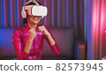 Neon  asian woman dancing. Fashion model woman in neon light, portrait of beautiful model with fluorescent make-up, Art and future design of female disco dancer posing in UV, colorful make up. 82573945