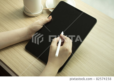Woman's hand and electronic pencil working with tablet 82574158