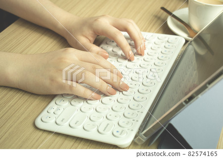 Woman's hand typing on a wireless keyboard 82574165