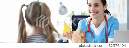 Pediatrician doctor tells little girl benefits of healthy eating Pediatrician doctor tells little girl benefits of healthy eating 82574404