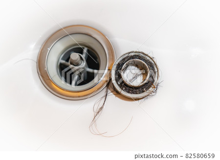 A photo of hair loss stuck in the drain of a bath. Image of trouble around water. Clogged water. 82580659