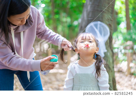 Mom wearing insect repellent on her child 82581245