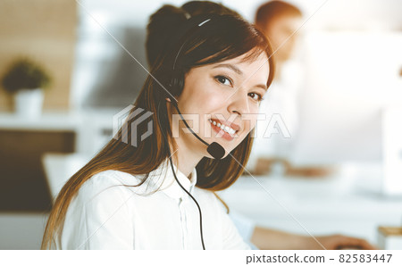 Asian woman working at customer service office. Business concept. Group of diverse operators at work in sunny call center. Asian woman working at customer service office. Business concept. Group of diverse operators at work in sunny call center. 82583447