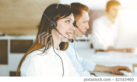 Asian woman working at customer service office. Business concept. Group of diverse operators at work in sunny call center. Asian woman working at customer service office. Business concept. Group of diverse operators at work in sunny call center. 82583460