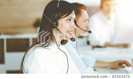 Asian woman working at customer service office. Business concept. Group of diverse operators at work in sunny call center. 82583473