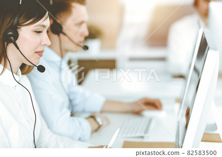 Asian woman working at customer service office. Business concept. Group of diverse operators at work in sunny call center. Asian woman working at customer service office. Business concept. Group of diverse operators at work in sunny call center. 82583500