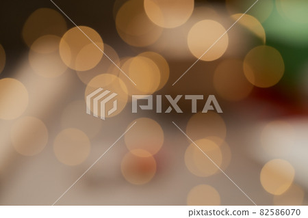 Blurred background of gift boxes and festive packaging with christmas light on a table closeup Blurred background of gift boxes and festive packaging with christmas light on a table closeup 82586070