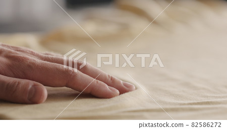 man touching yellow cotton clothes closeup man touching yellow cotton clothes closeup 82586272