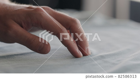man touching cyan cotton clothes closeup man touching cyan cotton clothes closeup 82586313