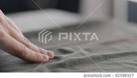 man touching green cotton clothes closeup man touching green cotton clothes closeup 82586327