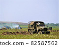 Military jeep supporting tanks in the meadow 82587562