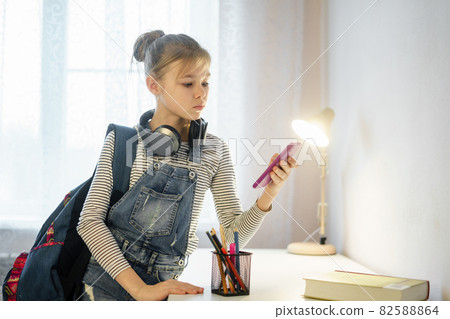 Young calm girl using her mobile phone to send a text 82588864