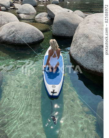 Beautiful yang lady relaxes on the paddle board Beautiful yang lady relaxes on the paddle board 82588972
