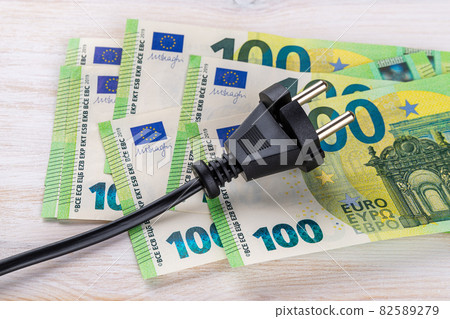 Black electric plug on one hundred euro banknotes. Rise in electricity prices concept. 82589279