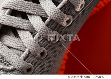 Lacing of gray textile sport shoes close-up. 82589290