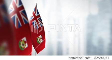 Small flags of Bermuda on a blurry background of the city 82590047