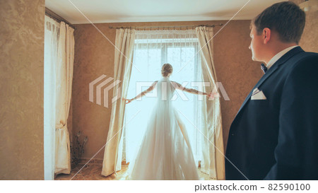 The groom approaches his young bride on their wedding day. 82590100
