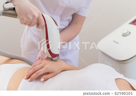 Woman on laser epilation procedure. Hardware removal of unwanted vegetation on hands Woman on laser epilation procedure. Hardware removal of unwanted vegetation on hands 82590101