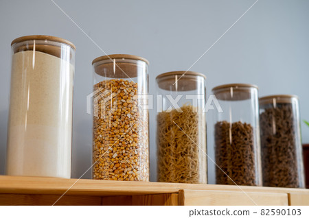 Glass jars with cereals in an eco friendly store. The concept of a grocery store without plastic disposable packaging Glass jars with cereals in an eco friendly store. The concept of a grocery store without plastic disposable packaging 82590103