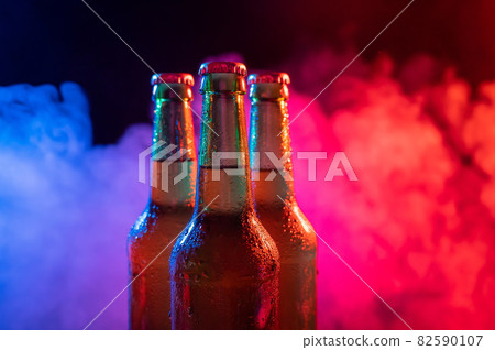 Three bottles of beer in a blue-pink mist. Three bottles of beer in a blue-pink mist. 82590107