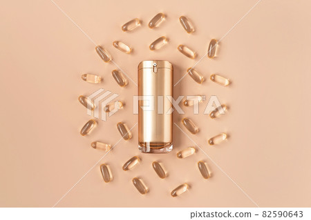Beautiful composition of gold mockup cosmetic bottle and vitamin capsules on pastel background. Natural anti-ageing cosmetics concept in trendy colors. Creative trendy cosmetics flat lay. Copy space. Beautiful composition of gold mockup cosmetic bottle and vitamin capsules on pastel background. Natural anti-ageing cosmetics concept in trendy colors. Creative trendy cosmetics flat lay. Copy space. 82590643