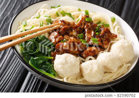 Indonesian food Mie ayam egg noodles with fried chicken meat and meatballs close-up in a bowl. horizontal 82590702