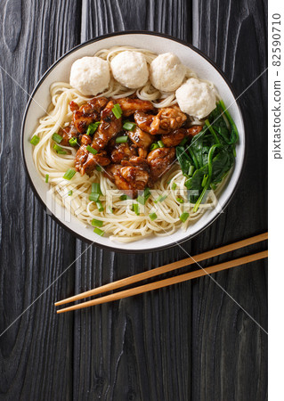 Mie ayam is one of the most popular noodle dishes in Indonesia, it yellow wheat noodles with diced chicken meat and meatball bakso closeup on the table. Vertical top view Mie ayam is one of the most popular noodle dishes in Indonesia, it yellow wheat noodles with diced chicken meat and meatball bakso closeup on the table. Vertical top view 82590710