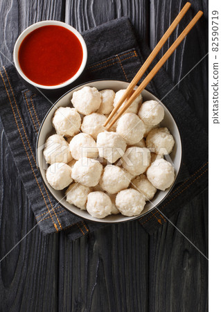 Bakso ayam Recipe Indonesian Meatballs from chicken with sauce close up in the bowl. Vertical top view Bakso ayam Recipe Indonesian Meatballs from chicken with sauce close up in the bowl. Vertical top view 82590719