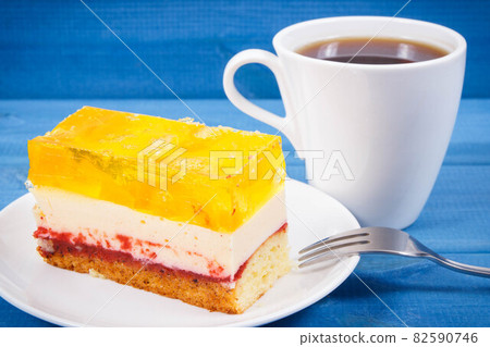 Creamy fruit cake with jelly and cup of coffee for different occasions. Festive dessert 82590746