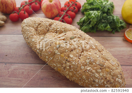 whole meal bread, apple and cherry tomato on table whole meal bread, apple and cherry tomato on table 82591940