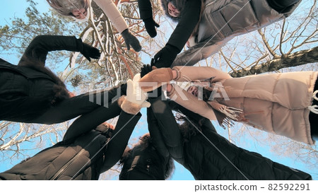 Girls friends join hands in the center on a winter day. 82592291