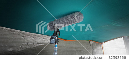 Microphone boom type. Sound recorder boom mic and tripod stand. Professional digital audio recording gear mic for making film or video movie production. Wind protection on boom mic. Movie industry Microphone boom type. Sound recorder boom mic and tripod stand. Professional digital audio recording gear mic for making film or video movie production. Wind protection on boom mic. Movie industry 82592366